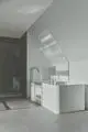 Badezimmer mit freistehender, moderner Wanne und Dusche in neutralen Tönen. Ideal Standard Produkte in minimalistischer, funktionaler Anordnung.